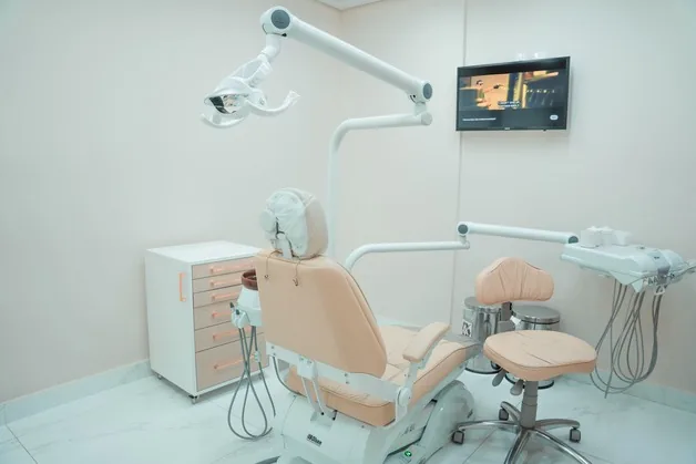 Consultório da clínica, com a cadeira de atendimento e o equipamento