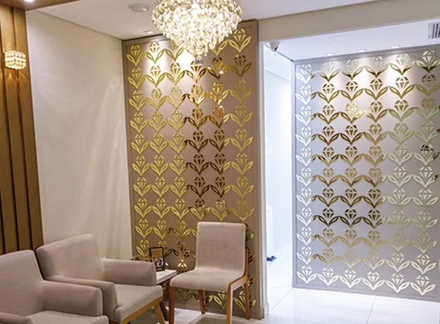 Recepção da clínica, com sofás, o painel dourado e o lustre